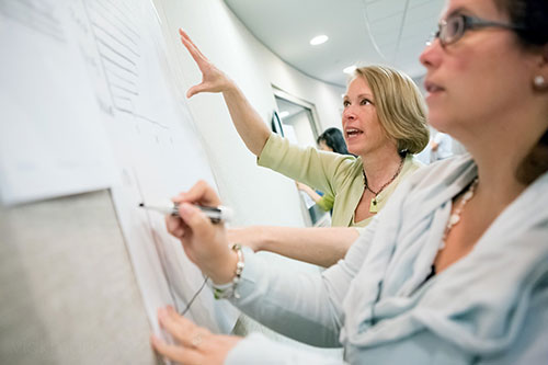 two women working at a bulletin board