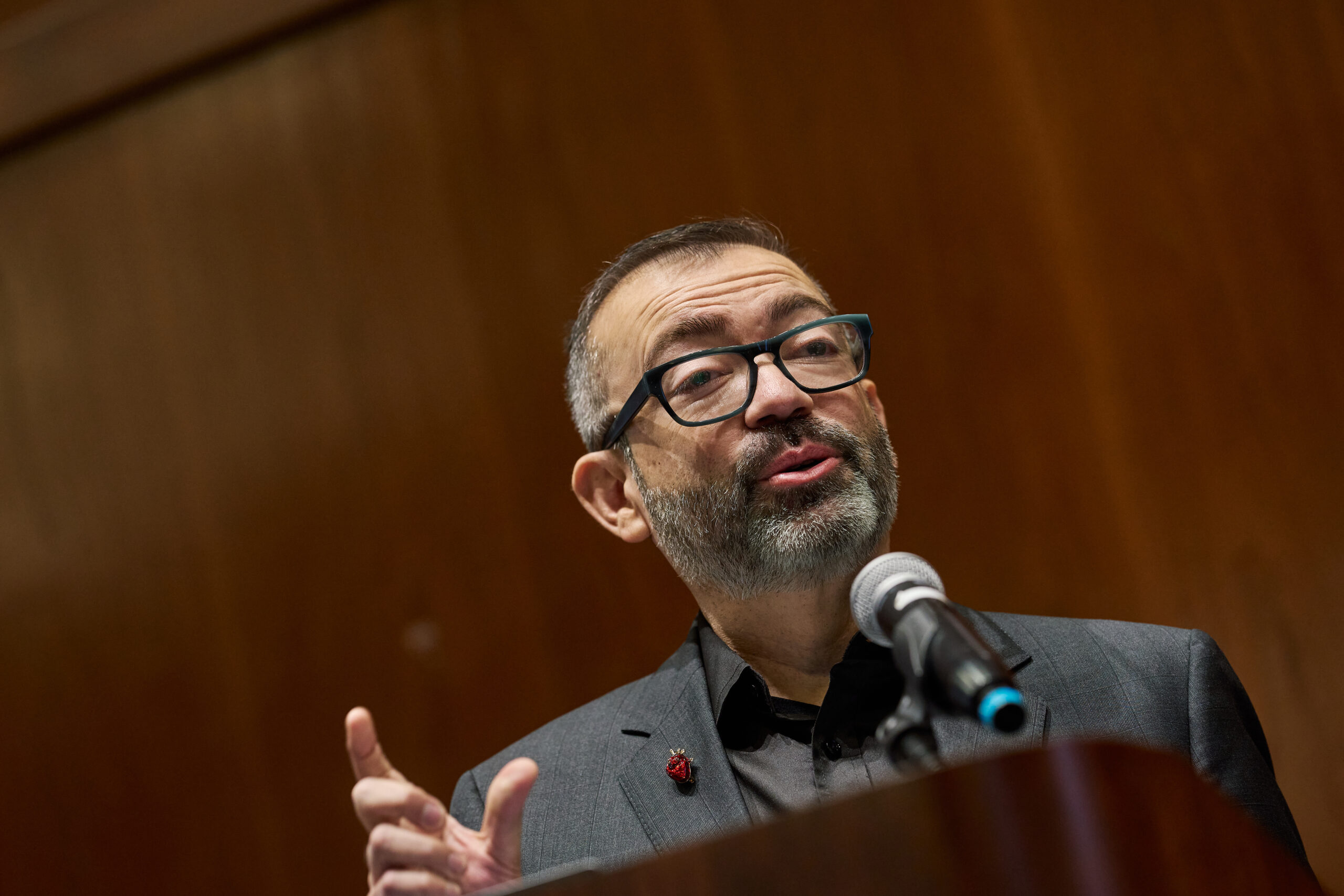 Robert Espinoza, MPA, CEO of National Skills Coalition, speaking behind a podium in front of a wood-paneled wall at the 2024 NCIOM annual meeting